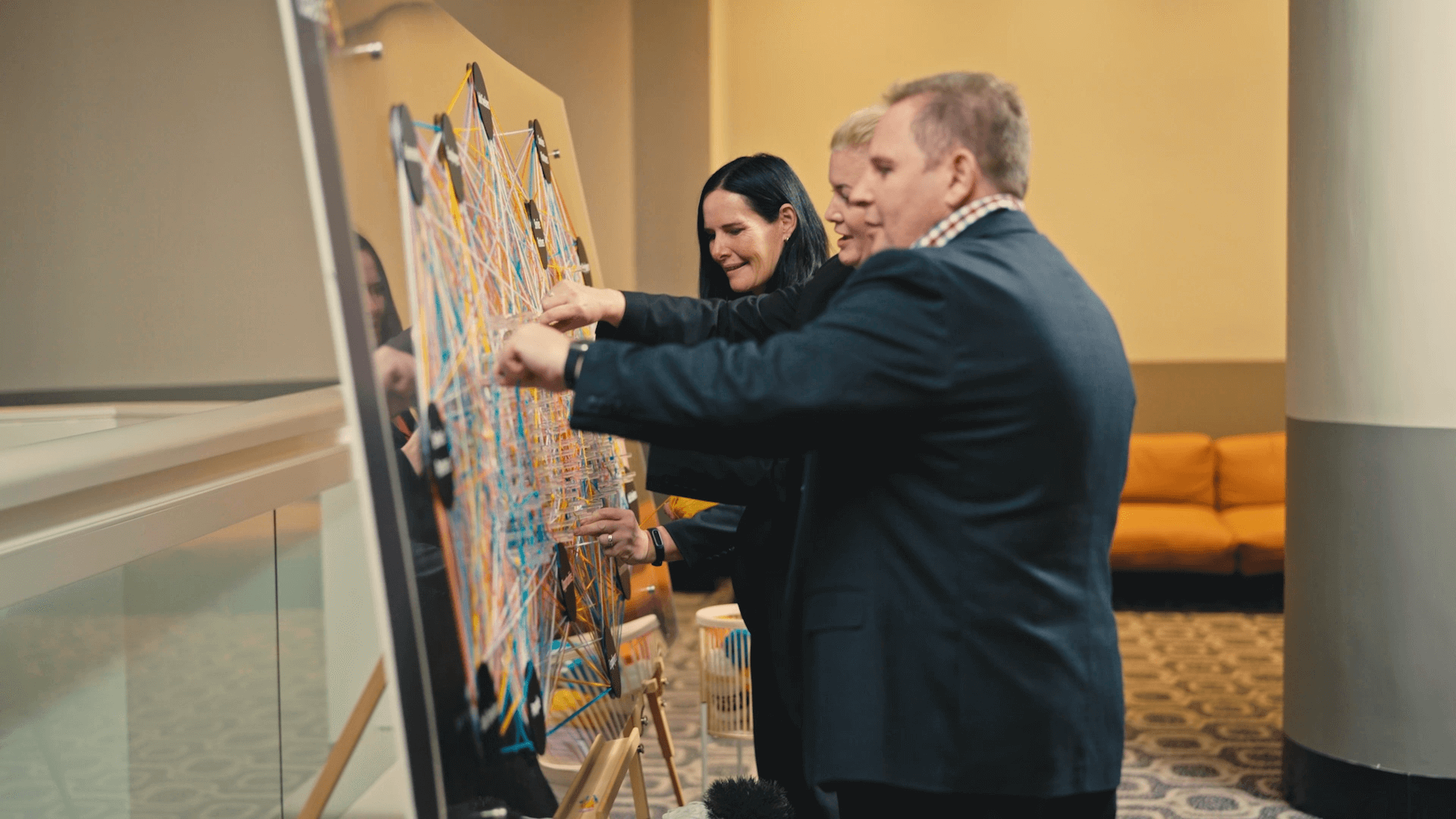 CoAct team members working on an artwork piece showing the important connections between CoAct and job seekers, service partners, employers, community, and government